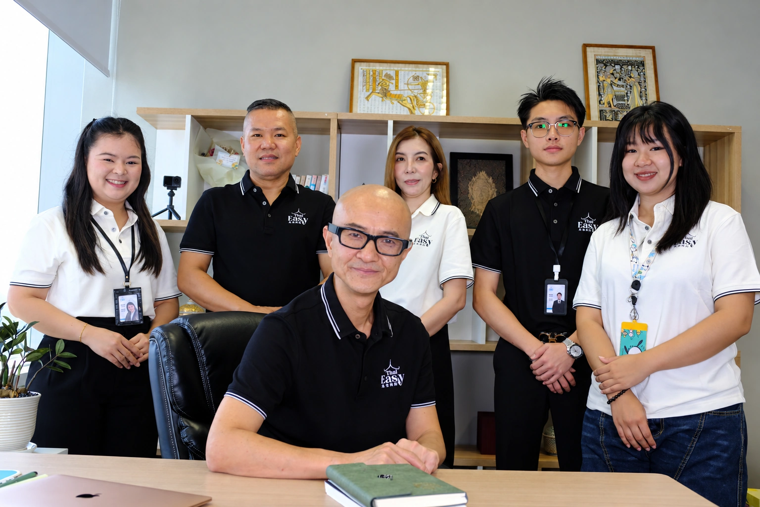 The Thai Easy team in the Bangkok office, with the founder seated at the desk